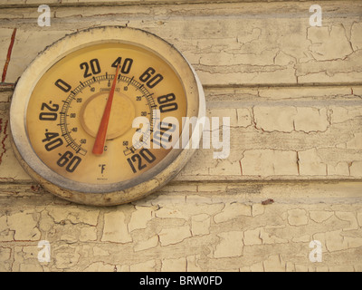 Un indicateur de température rustique sur un mur avec de la peinture. Banque D'Images