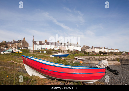 Bateau rouge sur la mer par le port dans un petit village de pêcheurs sur la côte nord-est du Nord-est. Craster, Northumberland, Angleterre, Royaume-Uni. Banque D'Images