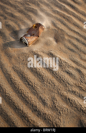 La vieille bière rouille peut à moitié enterrée dans le sable , Finlande Banque D'Images