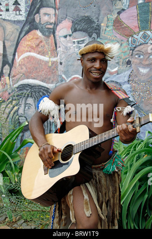 Guerrier zoulou homme posant comme avec la guitare. Banque D'Images