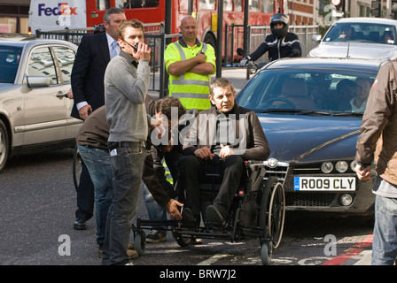 Rowan Atkinson dans un fauteuil roulant sur l'ensemble de Johnny English, le retour 2, à New Bridge Street, EC4, City of London, UK. Banque D'Images