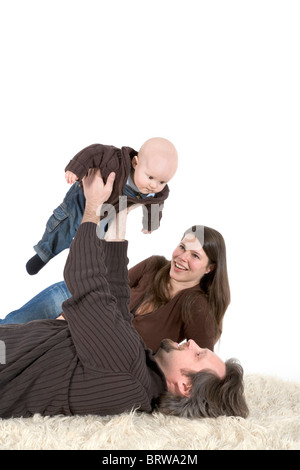 La famille, père, mère et bébé sur un tapis flokati Banque D'Images