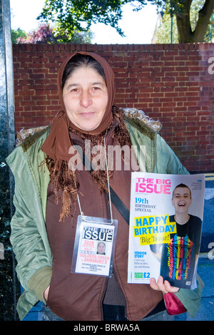 Golders Green , charmante dame ou une femme en foulard et des vêtements chauds de vendre le gros problème à l'extérieur du supermarché Sainsbury's store Banque D'Images