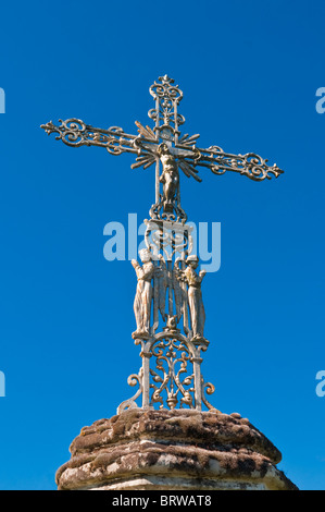 Les croix en fer forgé décoratif sur socle en pierre sculpté hexagonale - France. Banque D'Images