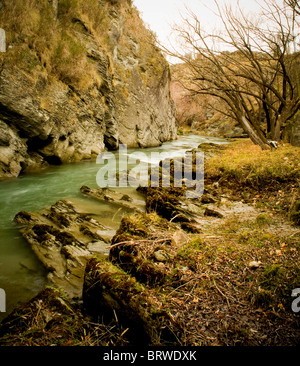 Petit cours d'eau entre un rocher et un remblai déserte Banque D'Images