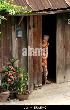 Une femme Lao ressemble dans la rue, de l'entrée de son domicile à Luang Prabang, Laos. Banque D'Images