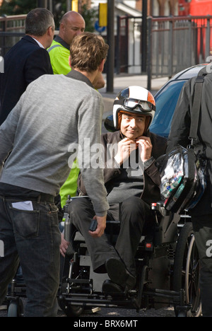 Rowan Atkinson, attache casque prépare pour l'action tondeuse fauteuil roulant motorisé sur Johnny English, le retour 2 London UK Banque D'Images