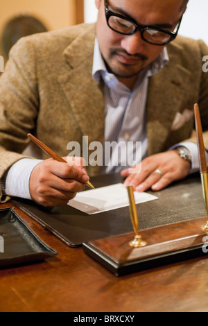 Homme mûr signature sur papier Banque D'Images