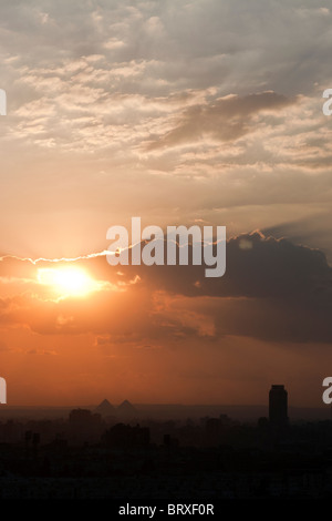 Coucher de soleil sur le Caire avec un aperçu des grandes pyramides à l'horizon, l'Égypte. Banque D'Images