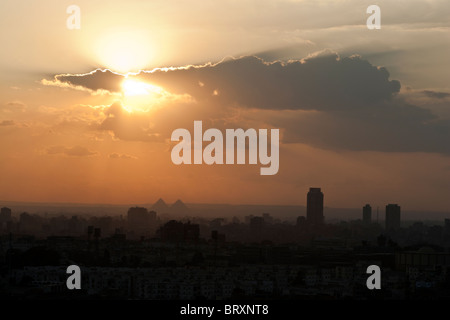 Coucher de soleil sur le Caire avec un aperçu des grandes pyramides à l'horizon, l'Égypte. Banque D'Images