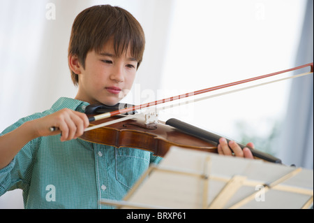 Mixed Race boy playing violin Banque D'Images