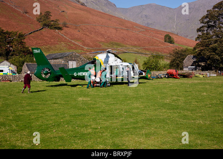 Great North Air Ambulance, Cumbria. L'équipage d'une ambulance les ambulanciers et porteurs d'une dame âgée à l'hélicoptère. Banque D'Images