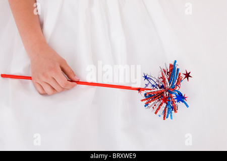 Close-up of girl (8-9) holding Quatrième de juillet wand Banque D'Images