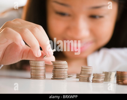 Close up of mixed race woman stacking coins Banque D'Images