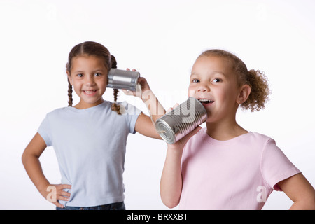 Deux jeunes filles (6-7, 8-9) à jouer avec tin can phone Banque D'Images