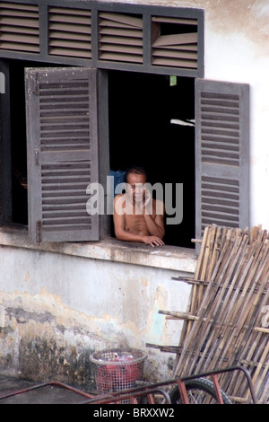 Un homme amputé et victimes des UXO est à la fenêtre de sa chambre d'hôpital au Centre national de réhabilitation à Vientiane au Laos. Banque D'Images