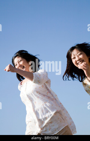Deux jeunes femmes s'exécutant sous ciel bleu Banque D'Images