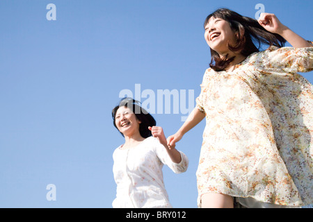 Deux jeunes femmes s'exécutant sous ciel bleu Banque D'Images