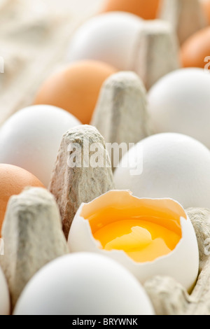 Le blanc et le brun oeufs dans le carton avec les oeufs cassés Banque D'Images