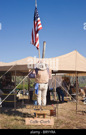 Le drapeau américain est soulevée à la Lincoln County Cowboy Symposium et Chuck Wagon Cook-Off, Ruidoso Downs, Nouveau Mexique. Banque D'Images