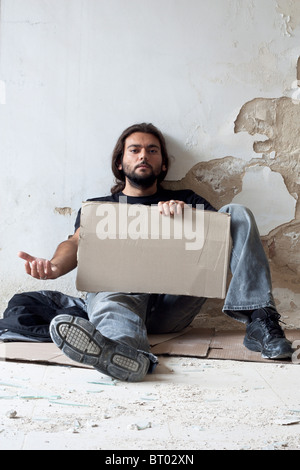 Mendiant assis sur le plancher Banque D'Images