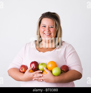 Portrait of smiling young woman holding fruits Banque D'Images