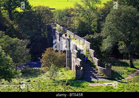 Les promeneurs sur Barden Bridge sur la rivière Wharfe près de Bolton Abbey, Yorkshire Dales National Park, North Yorkshire, Angleterre, Royaume-Uni. Banque D'Images