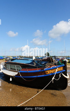 Un bateau amarré à marée basse à Blakeney sur la côte nord du comté de Norfolk Banque D'Images