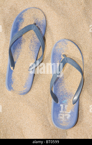 Tongs bleu sur la plage. Banque D'Images