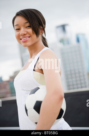 Asian teenage girl holding soccer ball Banque D'Images