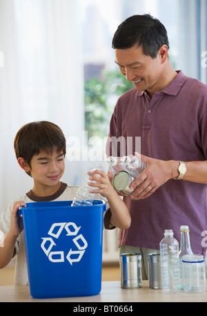 Père et fils le recyclage des bouteilles en plastique et boîtes de conserve Banque D'Images