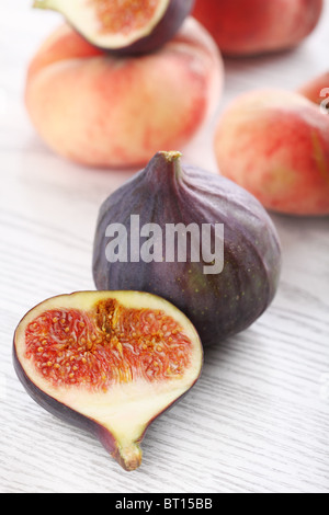 Figues fraîches et de pêches sur le fond en bois blanc Banque D'Images