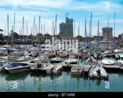 Les petites embarcations et de bateaux de plaisance dans le port de La Rochelle en France avec le anciennes tours de St Nicolas et le Boucher Banque D'Images