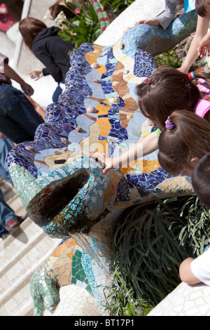 Les enfants à l'art de Gaudi's Chamelon à l'entrée du Parc Guell Barcelone Espagne Banque D'Images