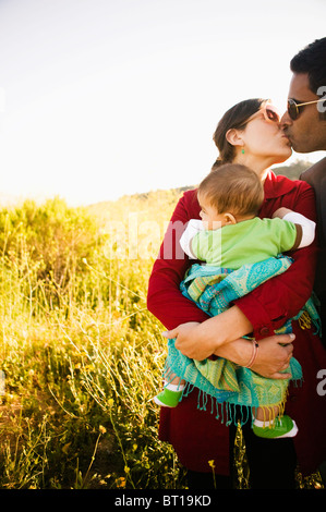 Mother holding baby et les baisers mari Banque D'Images