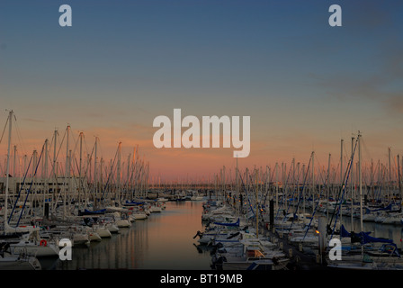 Coucher du soleil avec ses couleurs dancing off des nombreux voiliers et yachts amarrés dans le port de plaisance des Minimes, La Rochelle Charente-Maritime France. Banque D'Images