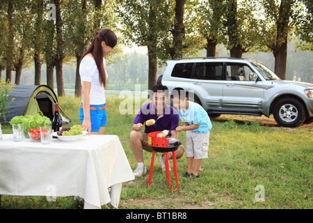 Cuisson de la famille maïs doux sur le barbecue Banque D'Images