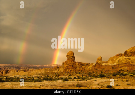 Un double arc-en-ciel apparaît après un orage passe sur les formations de grès dans le Parc National des Arches près de Moab dans l'Utah. Banque D'Images