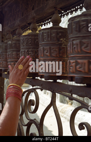 Une adoratrice du bouddhiste fait tourner les roues de prière à Bodnath Stupa, Kathmandu Banque D'Images