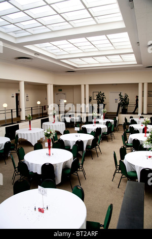 Un hall au toit de verre prêt pour une réception de mariage et partie à prendre place. Banque D'Images