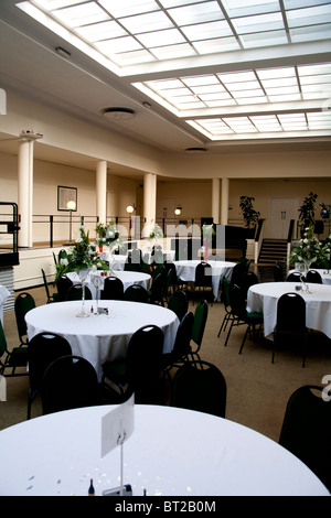 Un hall au toit de verre prêt pour une réception de mariage et partie à prendre place. Banque D'Images