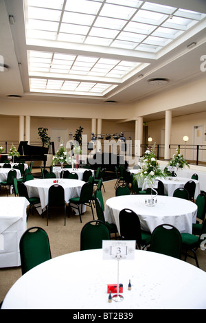 Un hall au toit de verre prêt pour une réception de mariage et partie à prendre place. Banque D'Images