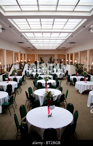 Un hall au toit de verre prêt pour une réception de mariage et partie à prendre place. Banque D'Images