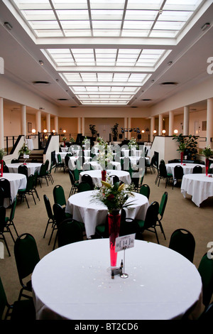 Un hall au toit de verre prêt pour une réception de mariage et partie à prendre place. Banque D'Images