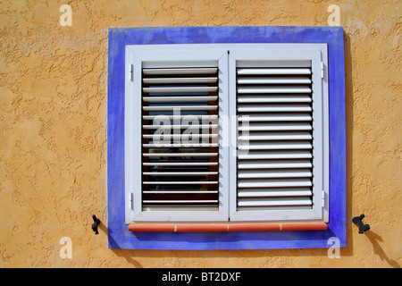 Fenêtre bois méditerranéens cadre bleu mur jaune Banque D'Images