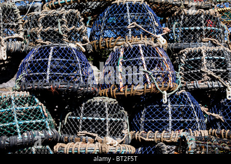 Des casiers à crabe et homard empilés sur le Harbourside, dans le port de pêche de Brixham, Devon, UK Banque D'Images