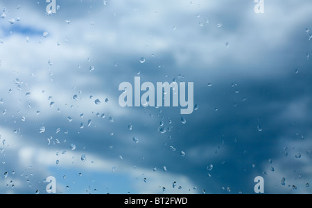 Gouttes de pluie sur le verre sur fond de ciel bleu Banque D'Images