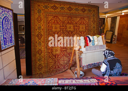 Femme travaillant sur un métier à tisser les tapis, Istanbul, Turquie Banque D'Images