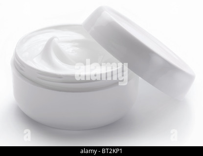 Ouvert contenant en plastique avec de la crème sur un fond blanc. Banque D'Images