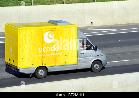 Vue latérale et aérienne de toit depuis le haut, vue vers le bas en jaune Ocado entreprise en ligne épicerie livraison de la camionnette et le logo Conducteur sur l'autoroute anglaise du Royaume-Uni Banque D'Images